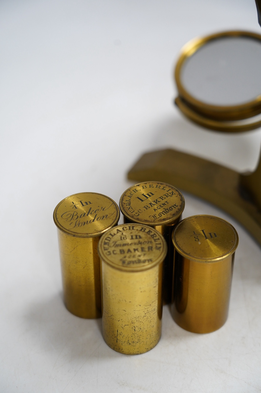 A 19th century brass compound binocular microscope, engraved to the base Baker, 244 High Holborn, London, with four brass cased objective lenses, 47cm high. Condition - fair to good